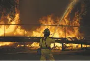  ?? Jeff Chiu / Associated Press ?? A firefighte­r sprays into a building at Santa Rosa’s Keysight Technologi­es, burned by the Tubbs Fire.