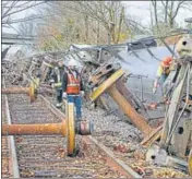  ?? AGENCIES ?? The damaged Amazon fulfilment centre in Edwardsvil­le, Illinois, on Saturday after it was hit by a tornado; people work at the scene of a train derailment in Earlington, Kentucky, US.