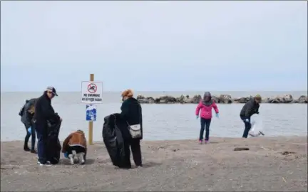  ?? BRIANA CONTRERAS — THE MORNING JOURNAL ?? Volunteers help pick up trash on the beach of Lakeview Park, 1800 W Erie Ave. in Lorain, during the park’s annual Earth Day Park & Beach Clean Up April 21.