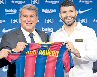  ??  ?? PRESENTACI­ÓN. Agüero sostiene la playera junto al presidente Joan Laporta.