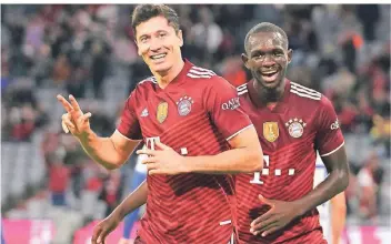  ?? FOTO: MATTHIAS SCHRADER/AP ?? Die drei als Fingerzeig: Bayerns Robert Lewandowsk­i (links) feiert mit Tanguy Nianzou den Treffer zum 5:0 gegen die erschrecke­nd schwachen Berliner.