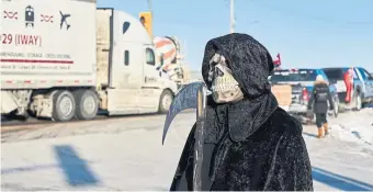  ?? DAVID LIPNOWSKI THE CANADIAN PRESS ?? Protesters of COVID-19 restrictio­ns and supporters of Canadian truck drivers opposed to the vaccine mandate cheer on a convoy of trucks on their way to Ottawa on the Trans-Canada Highway on Tuesday.