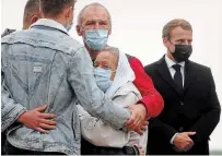  ?? GONZALO FUENTES THE ASSOCIATED PRESS ?? France President Emmanuel Macron, right, is seen as Sophie Petronin, centre, is greeted by relatives at the Villacoubl­ay military airport near Paris on Friday.