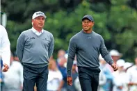  ?? JASON GETZ/THE ASSOCIATED PRESS ?? Fred Couples, left, and Tiger Woods talk Tuesday after their tee shots during a practice round for the Masters at Augusta National Golf Club in Augusta, Ga.