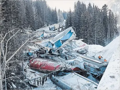  ?? JEFF MCINTOSH
THE CANADIAN PRESS ?? A Canadian Pacific freight train fell more than 60 metres from a bridge Monday near the Alberta-British Columbia border in a derailment that killed three crew members.