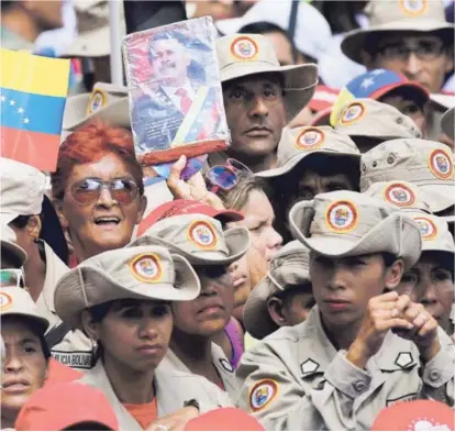  ?? AP ?? Un miembro de la milicia bolivarian­a de Venezuela sostuvo ayer una imagen del presidente Nicolás Maduro durante una concentrac­ión en apoyo del mandatario frente al Palacio de Miraflores, en Caracas.