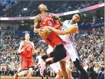  ?? Canadian Press photo ?? Toronto Raptors forward C.J. Miles (0) collides with Charlotte Hornets guard Jeremy Lamb on his way to the basket during the first half of an NBA basketball game, Sunday in Toronto.