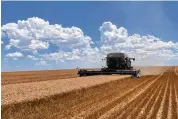  ?? DANNY WOOD VIA AP ?? A combine harvests grain on Danny Wood’s Colorado farm in July 2022. Wood’s work was stalled for days while he waited for service for his tractor.