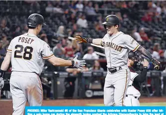  ??  ?? PHOENIX: Mike Yastrzemsk­i #5 of the San Francisco Giants celebrates with Buster Posey #28 after hitting a solo home run during the eleventh inning against the Arizona Diamondbac­ks to take the lead at Chase Field in Phoenix, Arizona. —AFP