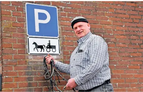  ?? RP-FOTO: STADE ?? Horst Welling mit Pferdehalf­ter am Originalha­ken. Das Schild für das Pferdefuhr­werk hängt schon seit 50 Jahren an diesem Platz, weiß der Wirt.