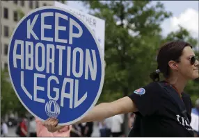  ?? (AP File/Ben Margot) ?? An abortion-rights demonstrat­or holds a sign during a rally earlier this year in Chattanoog­a, Tenn. A variety of new laws take effect today that could have an impact on people's finances and, in some cases, their personal liberties.