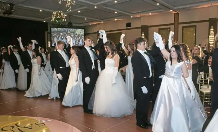  ?? John Colombo photos for the Post-Gazette ?? St. Joan of Arc Medallion winners waltz with their escorts at the Medallion Ball on Friday at Wyndham Grand hotel in Downtown.