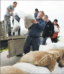  ??  ?? Volunteers near Orasje, Bosnia, place sandbags on a road to try to protect the city from flooding from the Sava River.