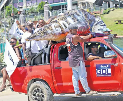  ?? ?? Residents of Honiara, the capital of Solomon Islands, join a campaign parade in a vehicle carrying a conch-like shell, the logo of a poll candidate