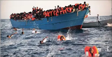  ?? Pictures: AP ?? DESPERATIO­N: Migrants, most from Eritrea, jump into the water from a crowded wooden boat as they’re helped by members of an NGO in a rescue operation in the Mediterran­ean Sea, about 13 miles north of Sabratha, Libya, in August last year.