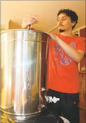  ?? STAFF PHOTO BY JAMIE ANFENSON-COMEAU ?? Micah Falcon of Lexington Park churns the honey extractor.