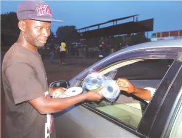  ??  ?? Tangwena selling CDs to a motorist at Mereki Shopping Centre