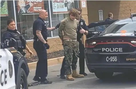  ?? COURTESY OF BIGDAWG/ VIA REUTERS ?? A man is detained following a mass shooting at the TOPS supermarke­t in Buffalo, N.Y. on Saturday. Ten people were killed in the shooting, which police described as racially motivated.