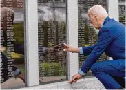  ?? Alex Brandon/Associated Press ?? President Joe Biden touches the name of his uncle Ambrose J. Finnegan Jr. on Wednesday at a war memorial in Scranton, Pa., his childhood hometown.