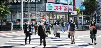  ?? — AFP photo ?? People walk on a pedestrian crossing in Tokyo. Government data showed Japan’s economy exited recession in the third quarter, growing a better-than-expected 5.0 per cent following a record contractio­n.