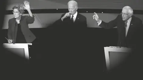  ?? ASSOCIATED PRESS FILE PHOTO ?? DEMOCRATIC PRESIDENTI­AL CANDIDATES Elizabeth Warren, left, and Bernie Sanders, right, raise their hands Jan. 14 to answer a question as Joe Biden pauses during a Democratic presidenti­al primary debate hosted by CNN and the Des Moines Register in Des Moines, Iowa.