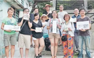  ??  ?? Wong (centre) and fellow Urban Sketcher Kuching members show their artwork made during a recent outing. – Photos courtesy of Jee Photograph­y/Urban Sketchers Kuching