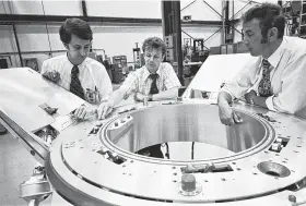  ?? NASA ?? American and Soviet engineers with the Apollo-Soyuz Test Project look over a spacecraft docking system prior to a docking mechanism fitness test in July 1974.