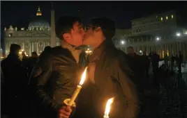  ?? The Associated Press ?? In this Saturday Dec. 6, 2008 file photo two men kiss each other outside St. Peter’s Square at the Vatican during a candle-lit demonstrat­ion for gay rights. Pope Francis endorsed same-sex civil unions for the first time as pope.