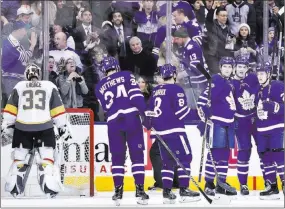  ??  ?? Golden Knights goalie Maxime Lagace fishes the puck out of the net as the Toronto Maple Leafs celebrate a goal by left wing James van Riemsdyk (25) on Monday night.