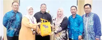  ?? ?? Siti Aminah (third right) receiving a memento from MARA Sabah during the visit.