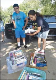  ?? NWA Democrat-Gazette/FLIP PUTTHOFF ?? Yahir Pina (left) and his mom, Veronica Esquivel, select books Tuesday. Books for adults and children are available for summer reading