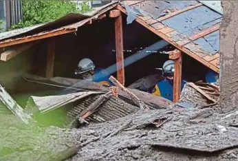  ?? (Foto A FP) ?? Anggota pengelamat mencari mangsa yang terperangk­ap dibawah runtuhan di lokasi kejadian tanah runtuh di Atami.