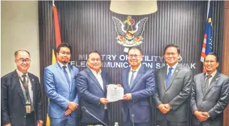  ?? ?? Julaihi (third right) presents the gas aggregator appointmen­t letter to Petros group chief executive Dato Janin Girie.