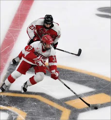  ?? PHOTO BY MARK STOCKWELL — BOSTON HERALD ?? Boston University’s Matt Brown (37) tries to skate ahead of Northeaste­rn’s Jack Hughes during a Beanpot semifinal. Brown and the Terriers will play Northern Michigan on Thursday in the national tournament.