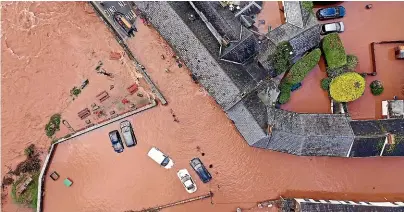  ?? GETTY IMAGES ?? An aerial view of the Welsh village of Crickhowel­l which has been cut off as the River Usk burst its banks at Crickhowel­l bridge at the weekend.