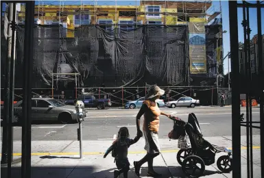  ?? Photos by Lea Suzuki / The Chronicle ?? Pedestrian­s on Valencia Street, across from a constructi­on project on what had been a parking lot and gas station. Developmen­t is squeezing out gas stations, low-margin businesses that occupy valuable real estate.