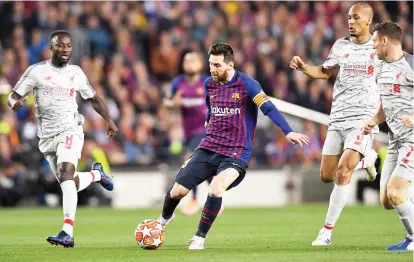  ?? — AFP photo ?? Barcelona’s forward Lionel Messi (second le ) is surrunded by Liverpool’s midfielder Naby Keita (le ), midfielder Fabinho and midfielder James Milner (right) during the UEFA Champions League semi-final first leg match between Barcelona and Liverpool at the Camp Nou Stadium in Barcelona.