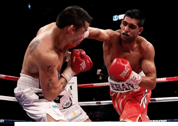  ?? Photo: ACTION IMAGES/LEE SMITH ?? HUMDINGER: Khan clatters his right off Maidana’s draw during epic scrap