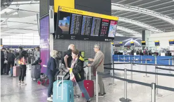  ?? ?? Passengers look at the departures board at Heathrow Airport, London, U.K., Aug. 28, 2023.