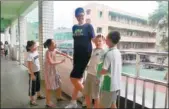  ?? GU AIGANG / CHENGDU ECONOMIC DAILY ?? Ren Keyu, a 2.06-meter-tall primary school student, hangs out with classmates in Leshan, Sichuan province, on Monday.