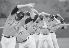  ?? LLOYD FOX/BALTIMORE SUN ?? Orioles pitchers, including David Hess (41), John Means (67) and Evan Phillips (58), stretch before the team’s rain-delayed practice session in Sarasota, Fla., on Wednesday.