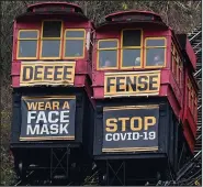  ?? (AP/Gene J. Puskar) ?? Cars on the Duquesne Incline in Pittsburgh pass each other Sunday while carrying signs that encourage mask-wearing.