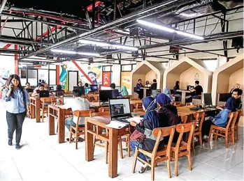  ?? GHOFUUR EKA/JAWA POS ?? NYAMAN DAN LEGA: Para pekerja lepas berkumpul di Koridor, salah satu co-working space di Surabaya, kemarin.