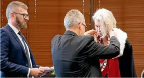  ?? TOM LEE/STUFF ?? Andrew King presents Paula Southgate with Hamilton’s mayoral chains as former council chief executive Richard Briggs, left, looks on.