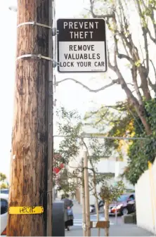  ??  ?? Shortly after a vehicle was broken into, Gerry McMahon (left) warns a tourist about leaving valuables in his car on Lombard Street, a popular spot for tourists as well as car break-ins. San Francisco has posted a sign below the crooked portion of...