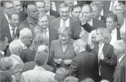  ?? ADAM BERRY/GETTRY IMAGES ?? German Chancellor Angela Merkel, center, casts her voteWednes­day on a third bailout package for eurozone member Greece. The measure passed 453-113.
