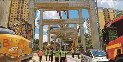  ??  ?? Policemen (in yellow vests) at the Sungai Besi-Ulu Klang Elevated Expressway constructi­on site in Kuala Lumpur where the incident occurred yesterday.