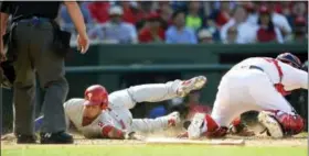  ?? NICK WASS — THE ASSOCIATED PRESS ?? Philadelph­ia Phillies’ Aaron Altherr, left, slides home to score as Freddy Galvis reached first on a fielders choice during the ninth inning of a baseball game against Washington Nationals catcher Matt Wieters, right, Sunday in Washington. The...