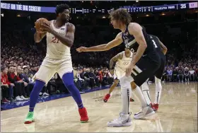  ?? CHRIS SZAGOLA — THE ASSOCIATED PRESS ?? The 76ers’ Joel Embiid looks to make his move on the Bucks’ Robin Lopez during the first half Dec. 25 in Philadelph­ia.