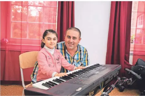  ?? RP-FOTO: THOMAS LAMMERTZ ?? Mit Hilfe des gespendete­n Keyboards will Narek Harutyunya­n auch seine fünfjährig­e Tochter unterricht­en.